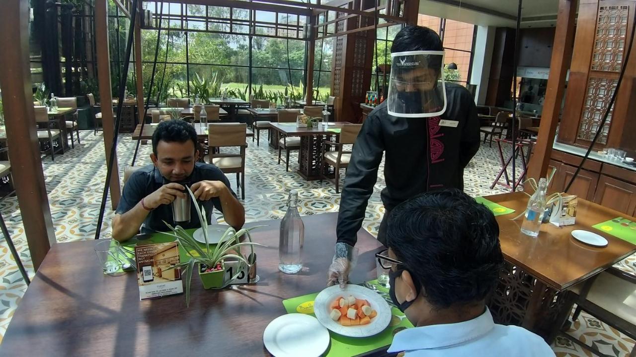 The Orchid Hotel Hinjewadi Pune Bagian luar foto A restaurant in India with a waiter wearing a face shield